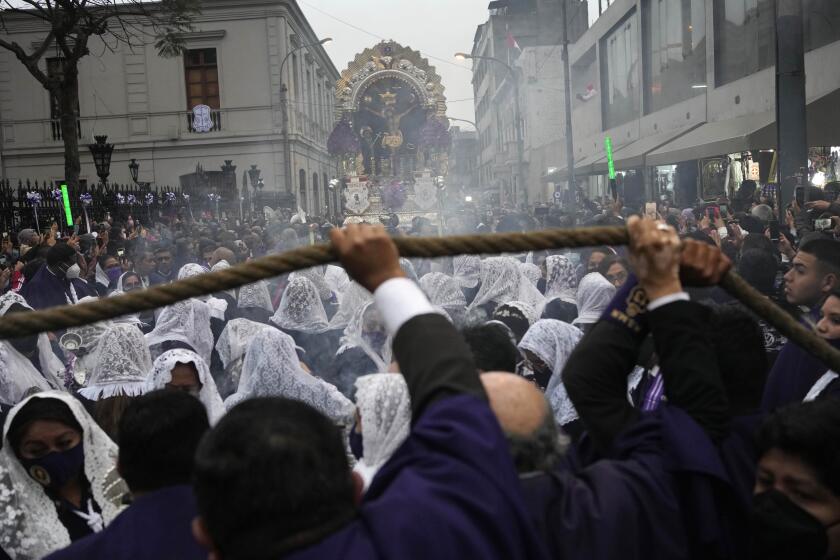 Mujeres con la cabeza cubierta por velos queman incienso durante una procesión.