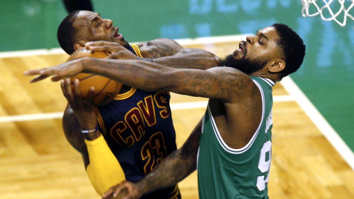 Cavaliers forward LeBron James tries to power his way to the basket against Celtics forward Amir Johnson during the first half Wednesday night.
