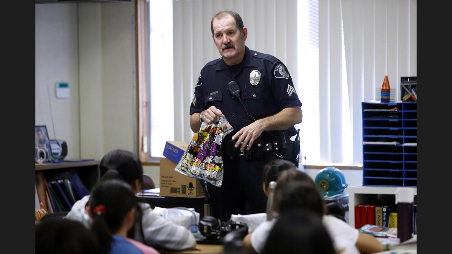 While visiting Mr. Scott Richmond's class, Glendale Police officer Ben Bateman shows a bag of Halloween goodies brought by officers for all students during the Cops for Kids event, at Verdugo Woodlands Elementary School, in Glendale on Tuesday, Oct. 24, 2017.