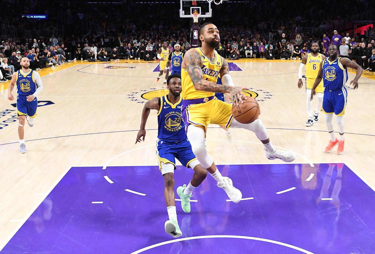 The Lakers' D'Angelo Russell drives to the basket against the Golden State Warriors' defense.