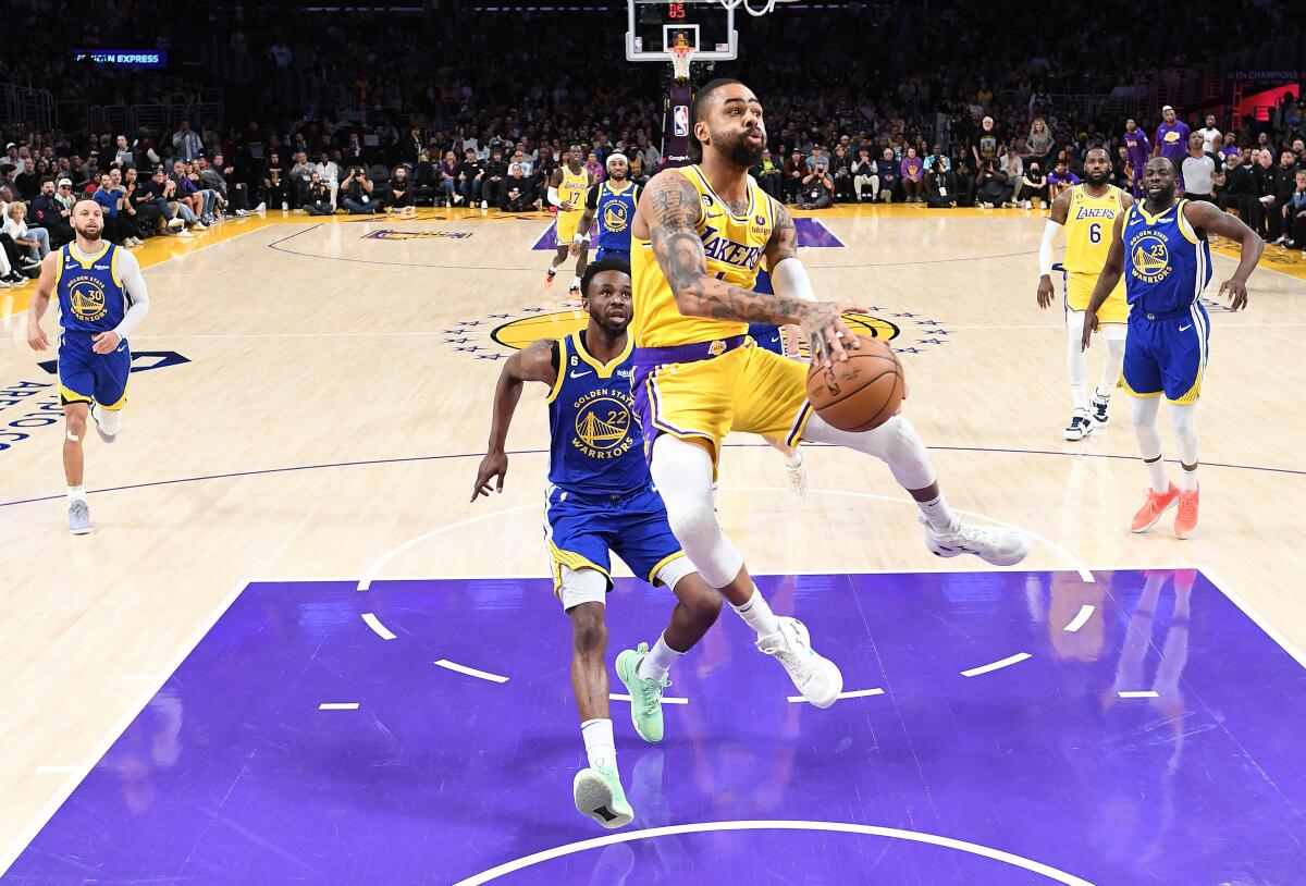 Lakers'tan D'Angelo Russell, Golden State Warriors'ın savunmasına karşı potaya doğru ilerliyor.