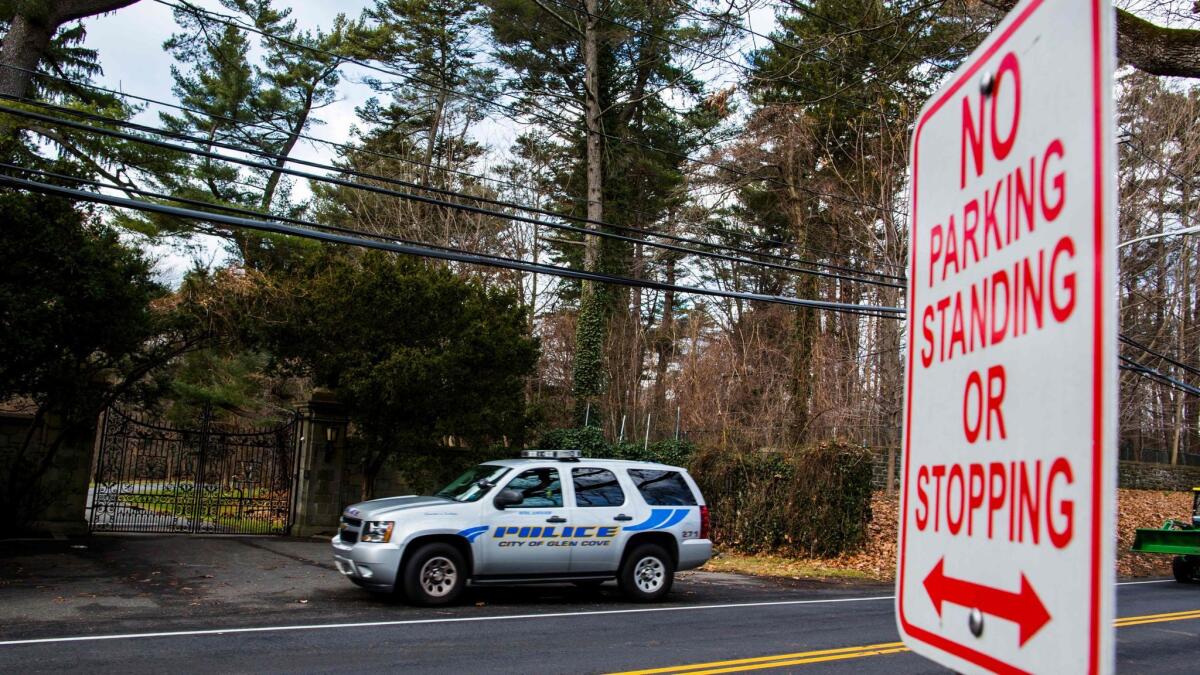 A police car guards the entrance of a Glen Cove, N.Y., estate that is being closed to Russian officials as part of the U.S. sanctions in retaliation for suspected hacking.
