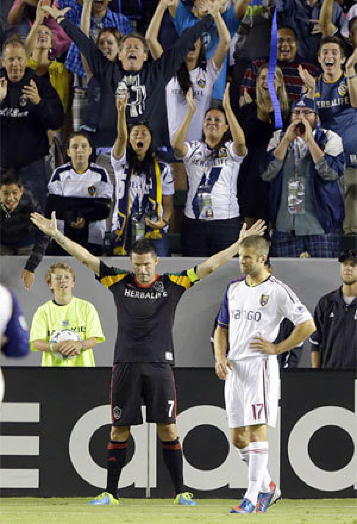 Galaxy forward Robbie Keane celebrates next to Real Salt Lake defender Chris Wingert after the second goal of his three goals on Saturday night.