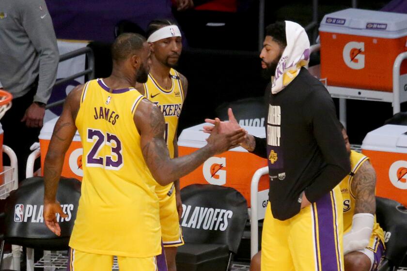 Lakers forward LeBron James exchanges a handshake with teammate Anthony Davis after a season-ending loss June 3, 2021.