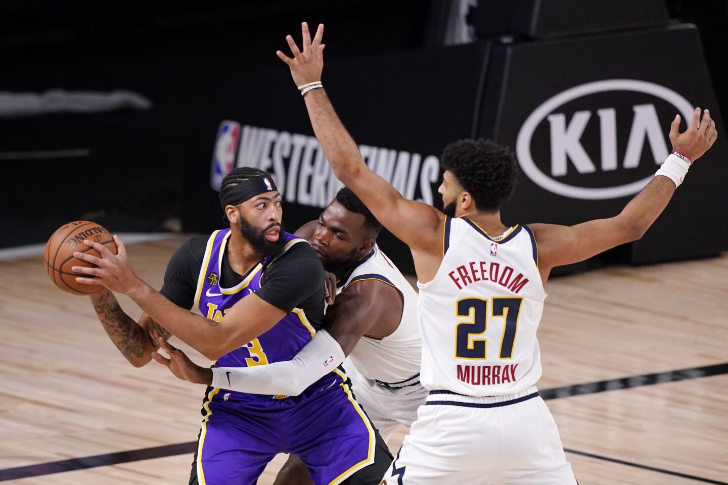 Lakers forward Anthony Davis faces the double-team defense of Denver's Paul Millsap and Jamal Murray.