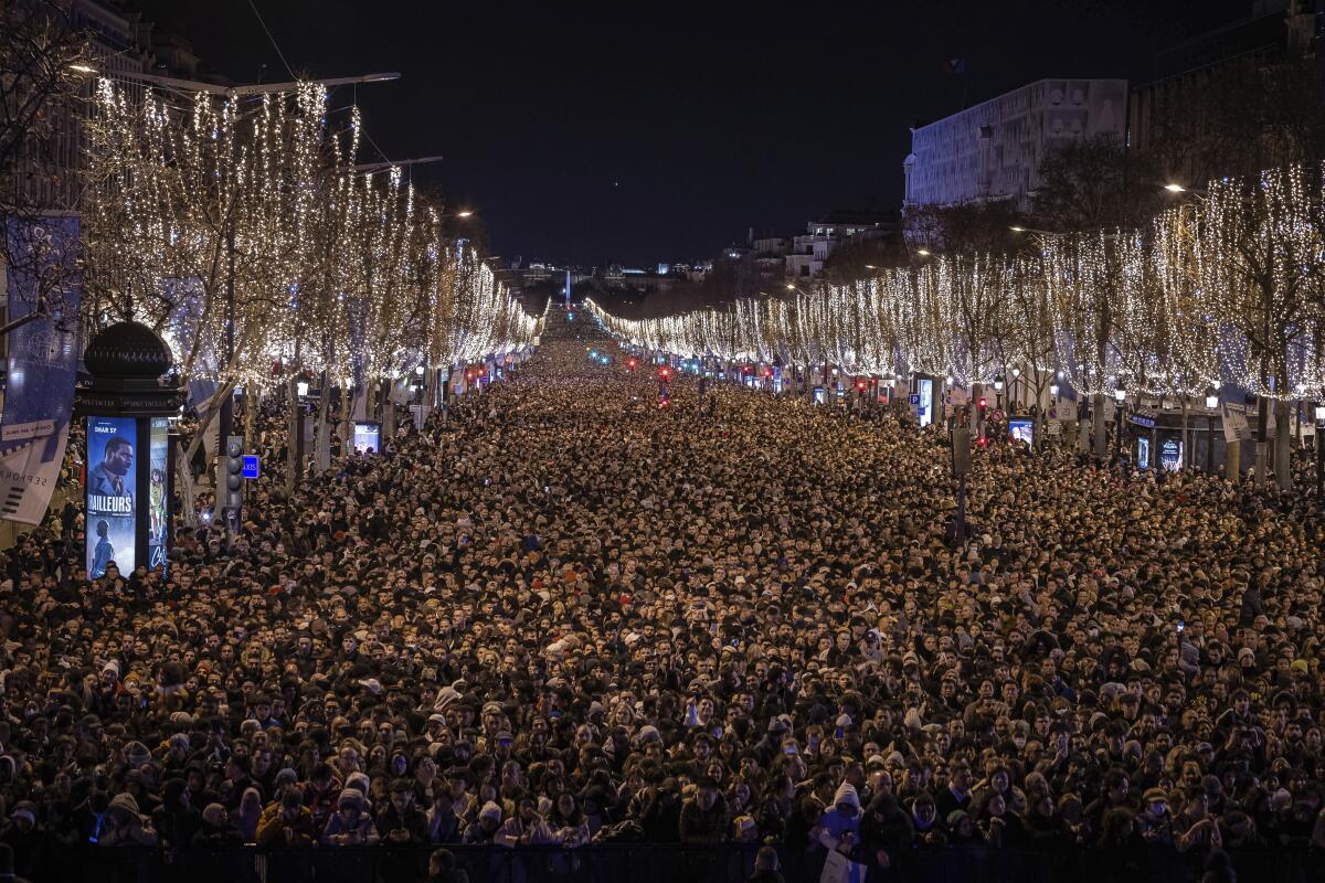 People fill the Champs Elysees in Paris on New Year's Eve.