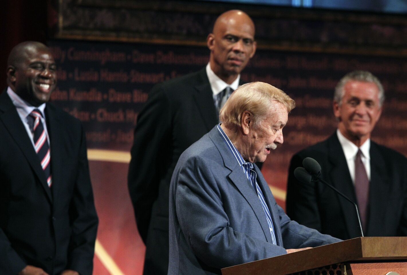 Jerry Buss, with Lakers legends Magic Johnson, Kareem Abdul-Jabbar and Pat Riley at his side, speaks during his Pro Basketball Hall of Fame enshrinement in Springfield, Mass.
