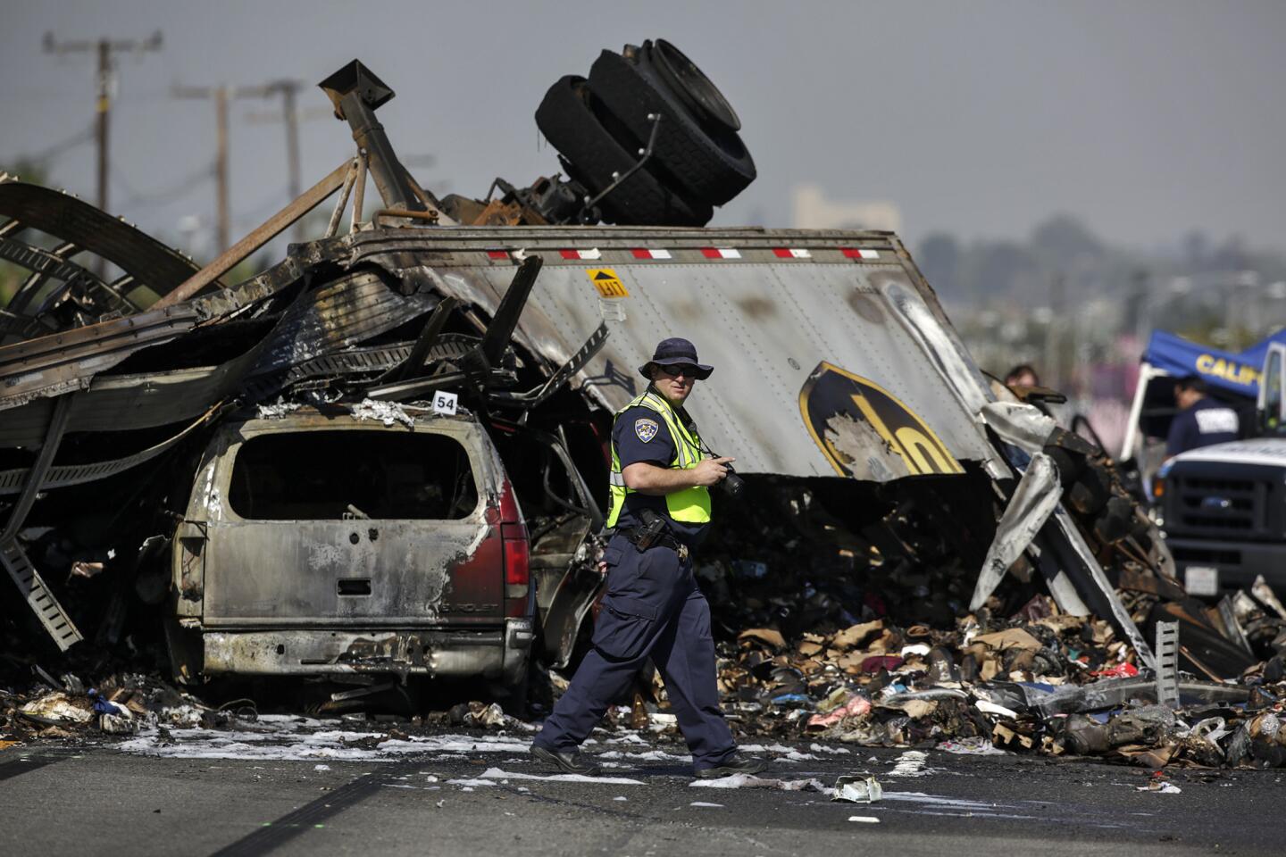 A California Highway Patrol investigator takes photographs at the scene of Saturday's multivehicle crash on the 5 Freeway in Commerce that killed three people.