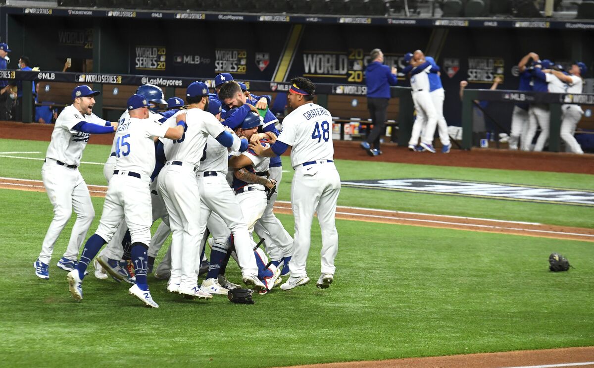 Dodgers players leap and pile together on the field.