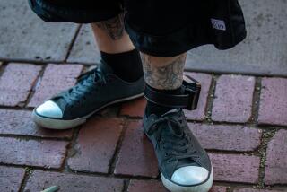 Los Angeles, CA - Portrait of Jamie Maier, 55, wearing an ankle bracelet standing in the outdoor courtyard at Amistad de Los Angeles, a prison re-entry facility Friday, Dec. 1, 2023, in Los Angeles, CA. (Francine Orr / Los Angeles Times)