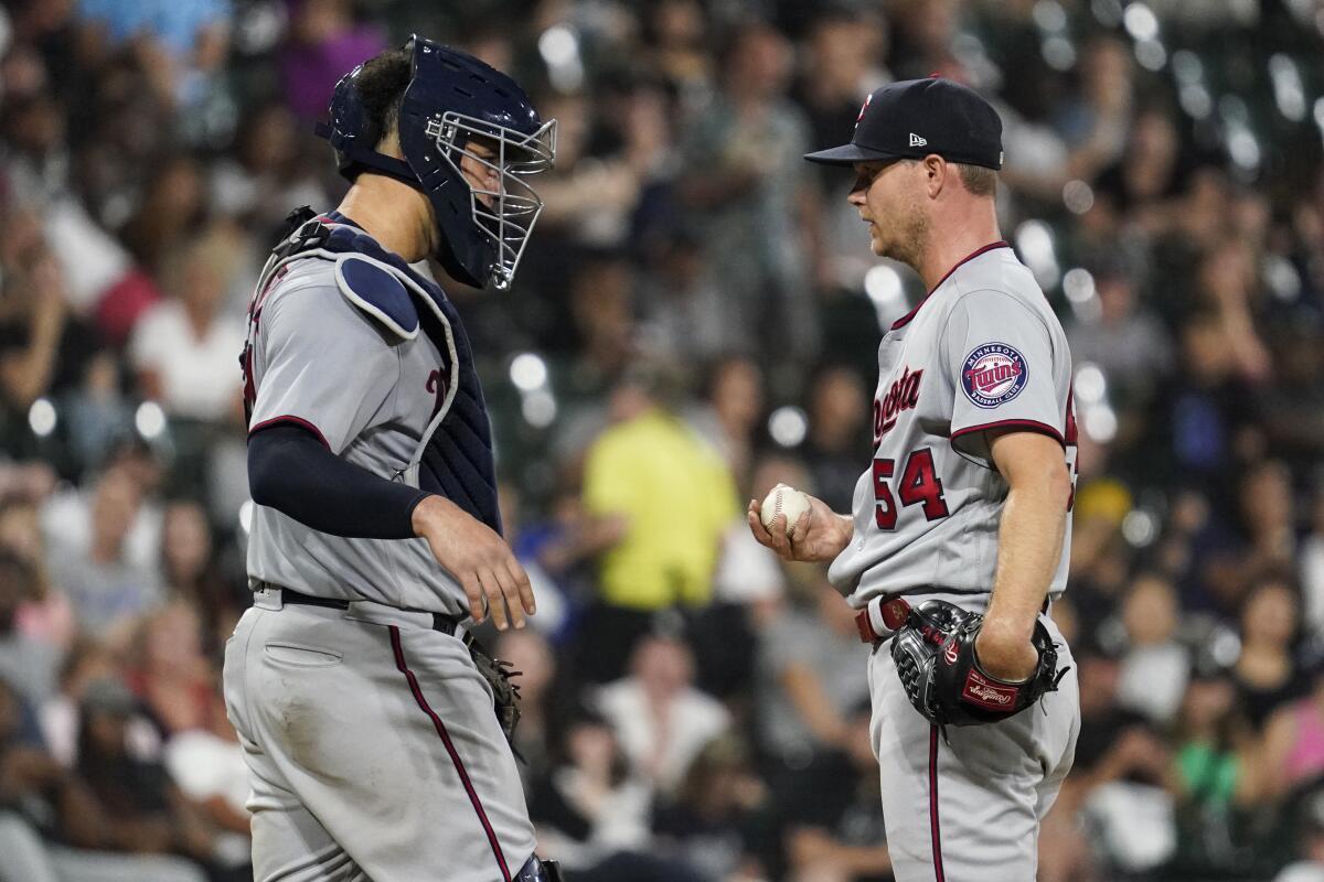 Minnesota Twins catcher Gary Sanchez, left, talks with starting pitcher Sonny Gray during the fourth inning of a baseball game against the Chicago White Sox in Chicago, Friday, Sept. 2, 2022. (AP Photo/Nam Y. Huh)