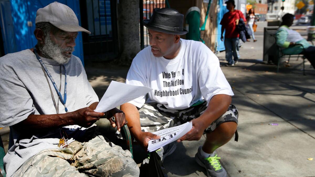 Community organizer General Jeff Page, right, speaks with Terry Prescod on skid row before last month's neighborhood council election.