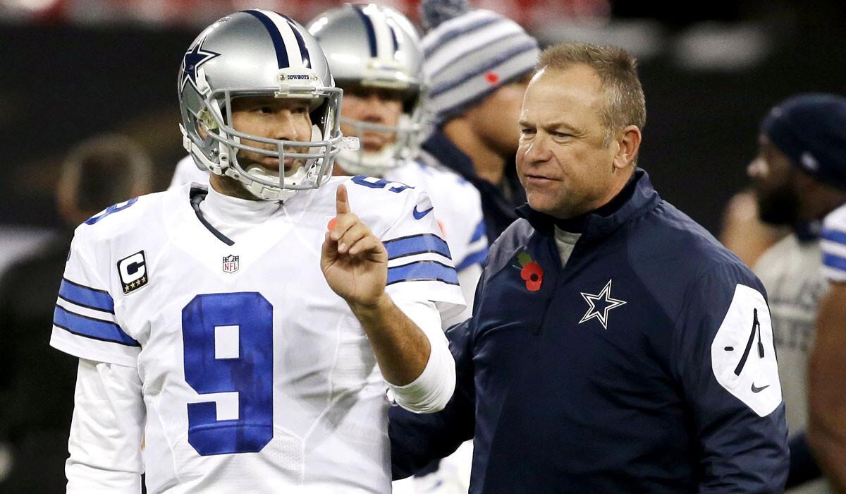 Cowboys quarterback Tony Romo (9) talks to passing game coordinator Scott Linehan before a game against the Jacksonville Jaguars at Wembley Stadium in London.