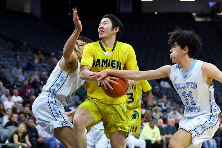 Damien's Bradley Xie tries to maintain control while being pressured by Clovis North's Christian Calvillo (right).