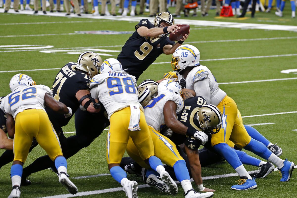 New Orleans Saints quarterback Drew Brees dives over the Chargers' defensive line to score a touchdown.