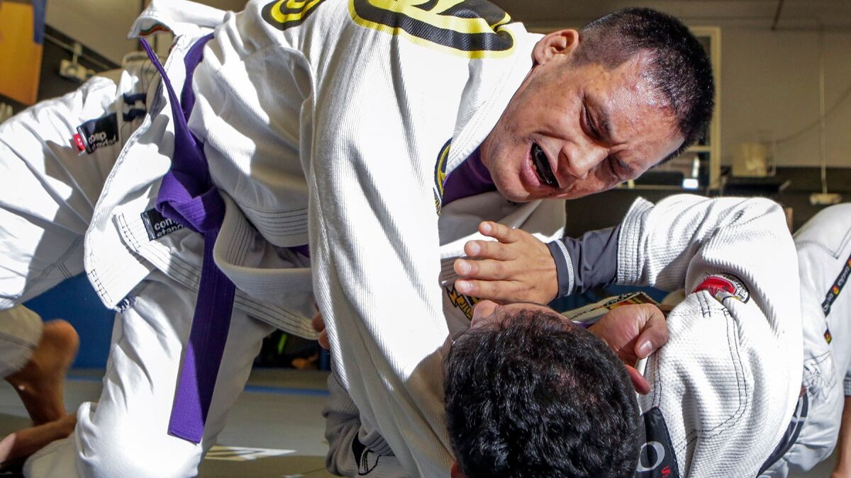 Jeff Mata, top, grapples with sparring partner Christian Lopez at the San Diego Brazilian Jiu-Jitsu Academy in San Marcos on Friday.