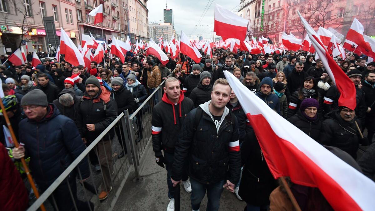 Demonstrators carry Polish national flags as they take part in the March of Independence 2017 under the slogan "We want God" as part of Polish Independence Day celebrations in Warsaw on Saturday.