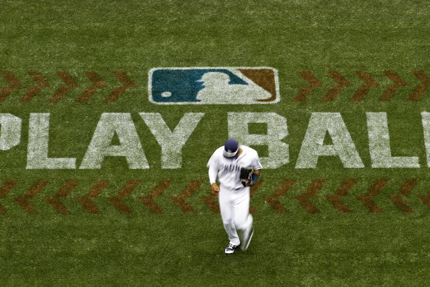 FILE - San Diego Padres left fielder Allen Cordoba passes a logo for Play Ball, an initiative from Major League Baseball and USA Baseball, during the fifth inning of a baseball game against the Colorado Rockies on June 3, 2017, in San Diego. Players voted Thursday, March 10, 2022, to accept MLB's offer on new labor deal, paving way to end 99-day lockout and salvage 162-game season. (AP Photo/Gregory Bull, File)