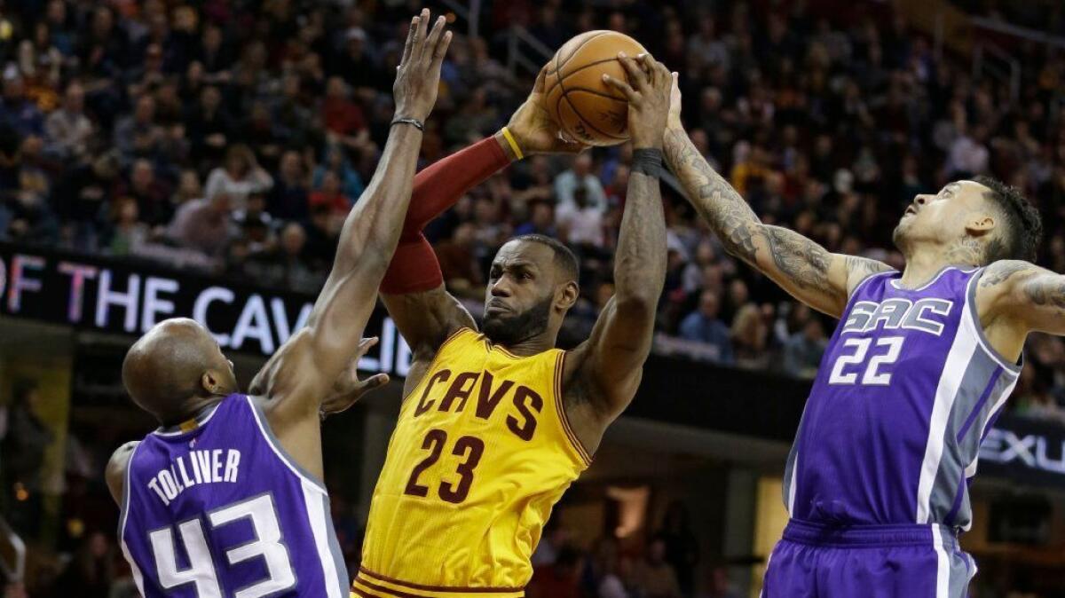 Cleveland forward LeBron James is defended by Sacramento's Anthony Tolliver (43) and Matt Barnes (22) during a game on Jan. 25.