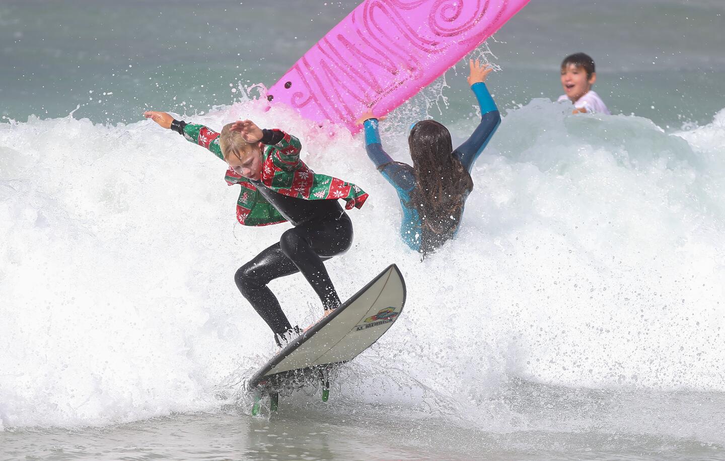 Kids ride in the Laguna Beach Surf School summer program Friday in Laguna Beach.