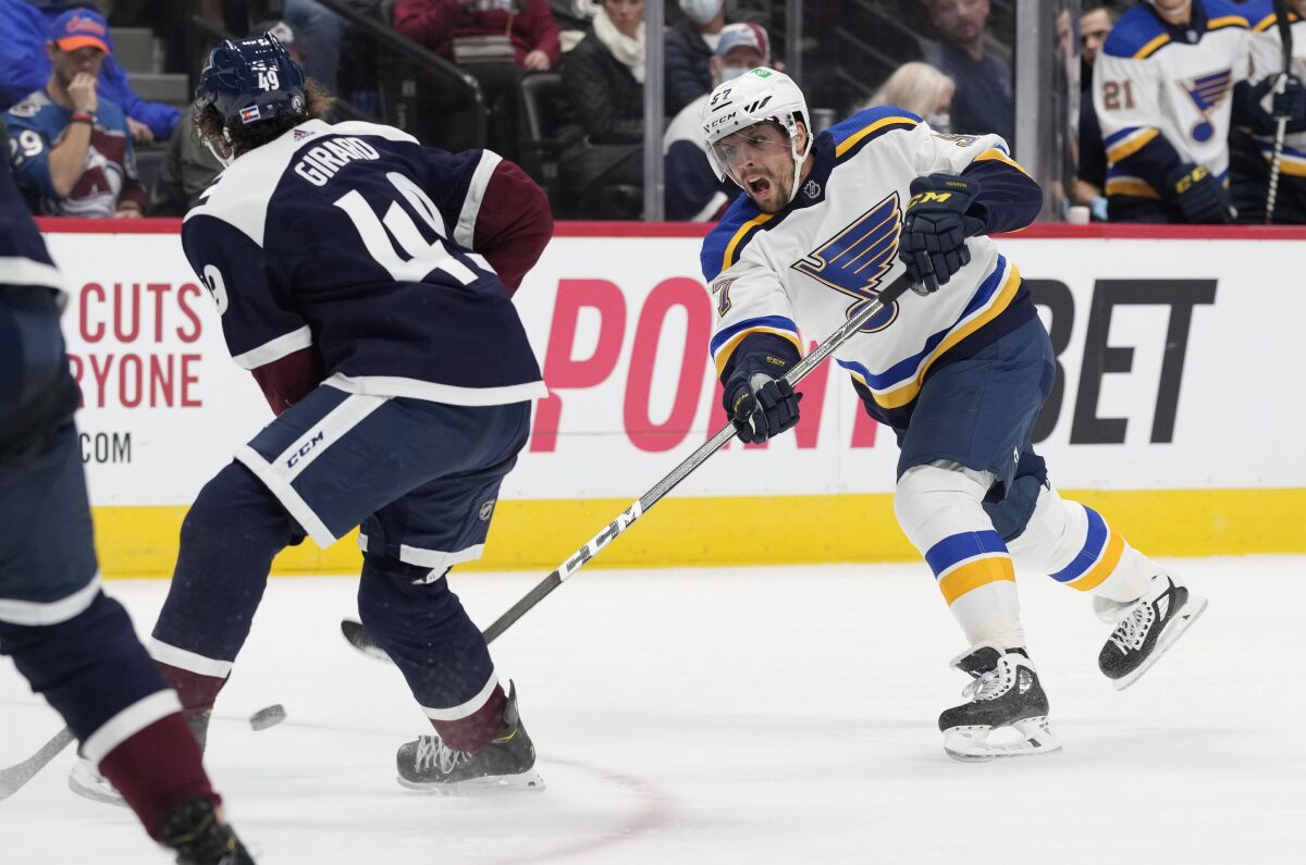 St. Louis Blues left wing David Perron, right, shoots a goal past Colorado Avalanche defenseman Samuel Girard in the second period of an NHL hockey game Saturday, Oct. 16, 2021, in Denver. (AP Photo/David Zalubowski)