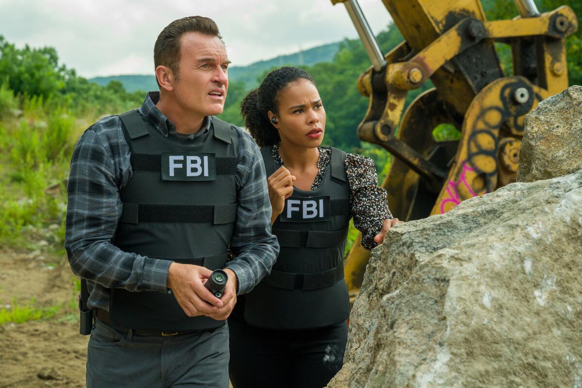  Two FBI agents stand among rocks in "FBI: Most Wanted" on CBS.