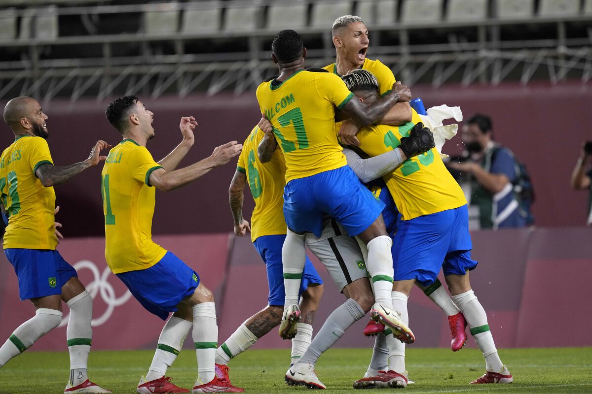 Brazil's players run and jump on each other.
