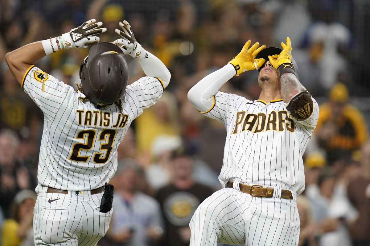 San Diego Padres' Manny Machado, right, reacts with teammate Fernando Tatis Jr. (23) after hitting a two-run home run during the seventh inning of a baseball game against the Houston Astros, Saturday, Sept. 4, 2021, in San Diego. (AP Photo/Gregory Bull)