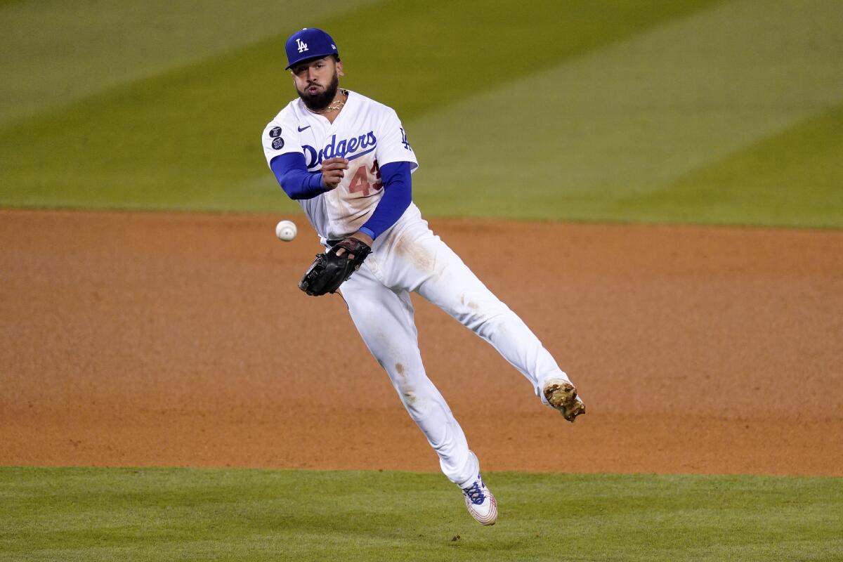 Dodgers third baseman Edwin Ríos throws out Cincinnati's Tucker Barnhart at first.