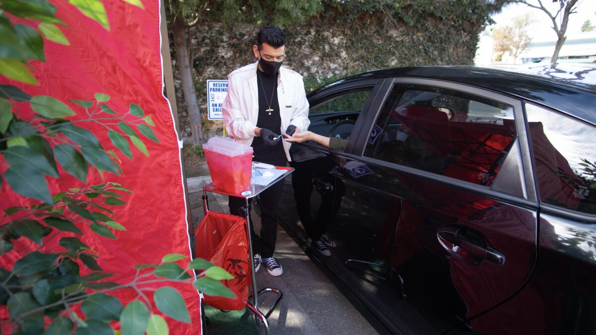 Manny Muroworks administers HIV testing in a drive-through setup.