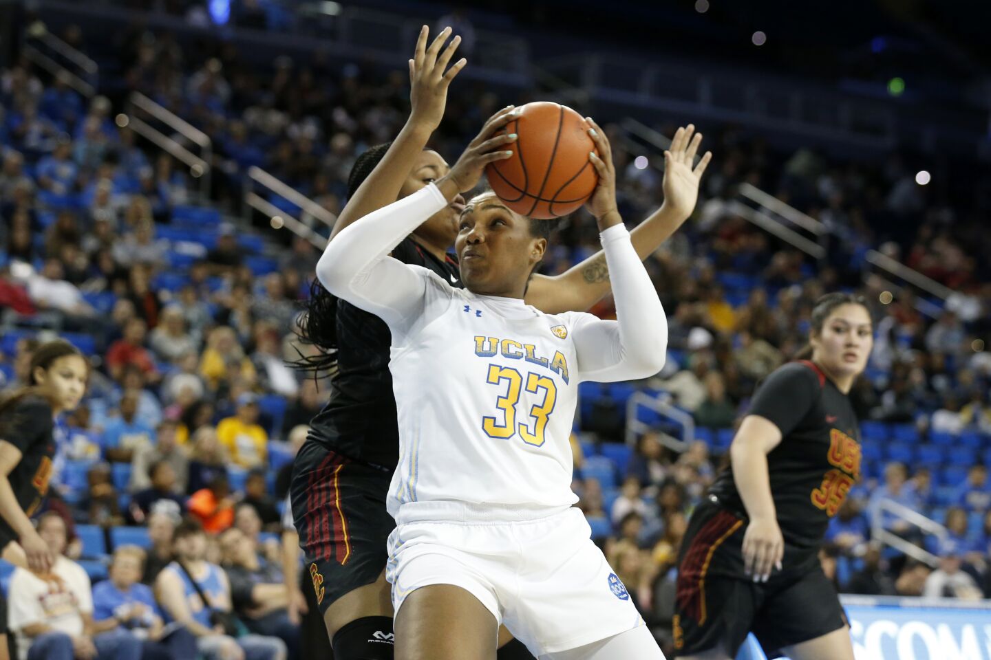 UCLA forward Lauryn Miller (33) drives to the basket in front of USC center Angel Jackson during the second half.