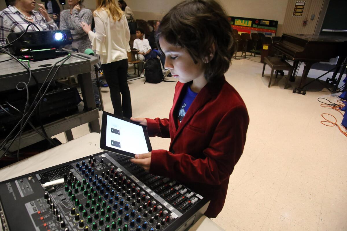 Jamison Karp, 9, uses an iPad for the music for the film "Jurassic Pork" during the premier of the second annual Fourth Grade Film Festival in the auditorium at Stevenson Elementary School on Wednesday.