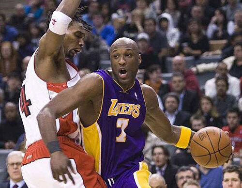 Lakers forward Lamar Odom, right, drives past Raptors forward Chris Bosh during the first half Wednesday in Toronto.