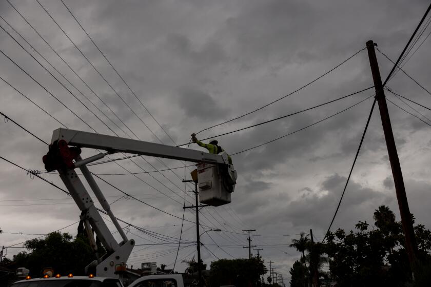 San Diego, CA - September 09: A crew from San Diego Gas & Electric restores power to a home after wiring was toppled as Tropical Storm Kay passed through the Normal Heights neighborhood on Friday, Sept. 9, 2022 in San Diego, CA. (Sam Hodgson / The San Diego Union-Tribune)