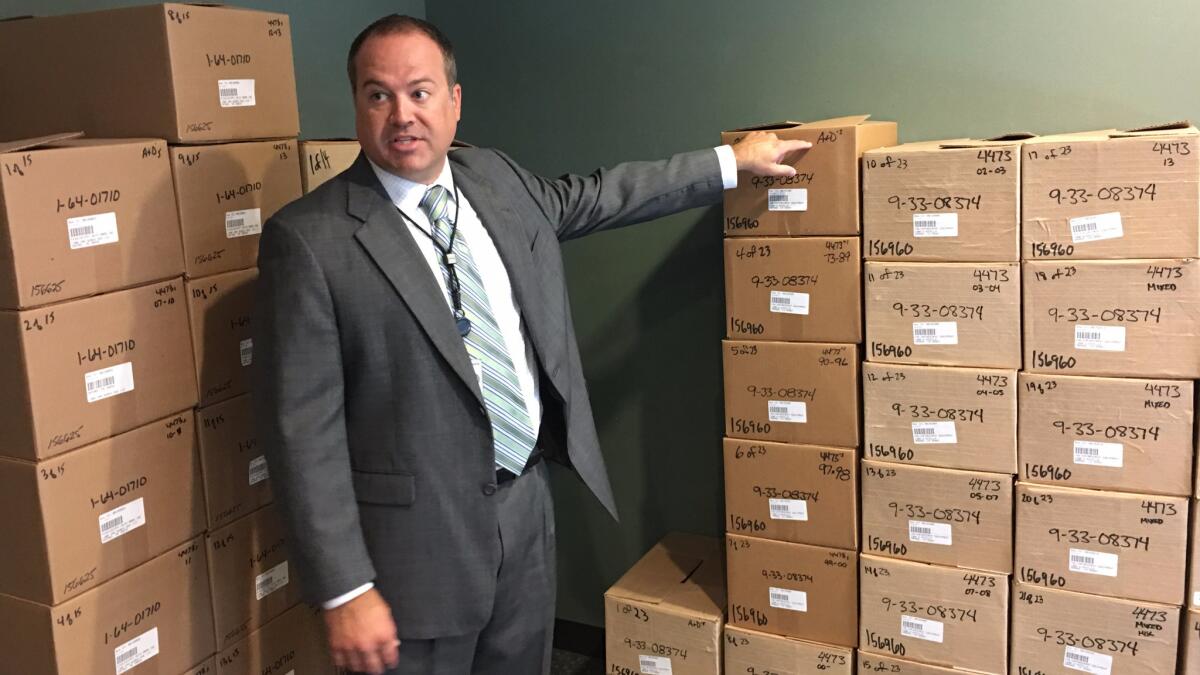 Neil Troppman, a manager of ATF's tracing center, stands next to boxes of firearms records that recently arrived at the agency's facility in West Virginia.