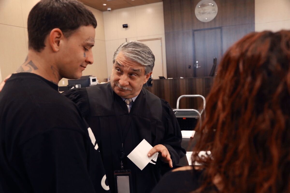 Judge Richard A. Vlavianos, center, asks probationer David Vieira if everything is going well for him during a collaborative courts session in Stockton.