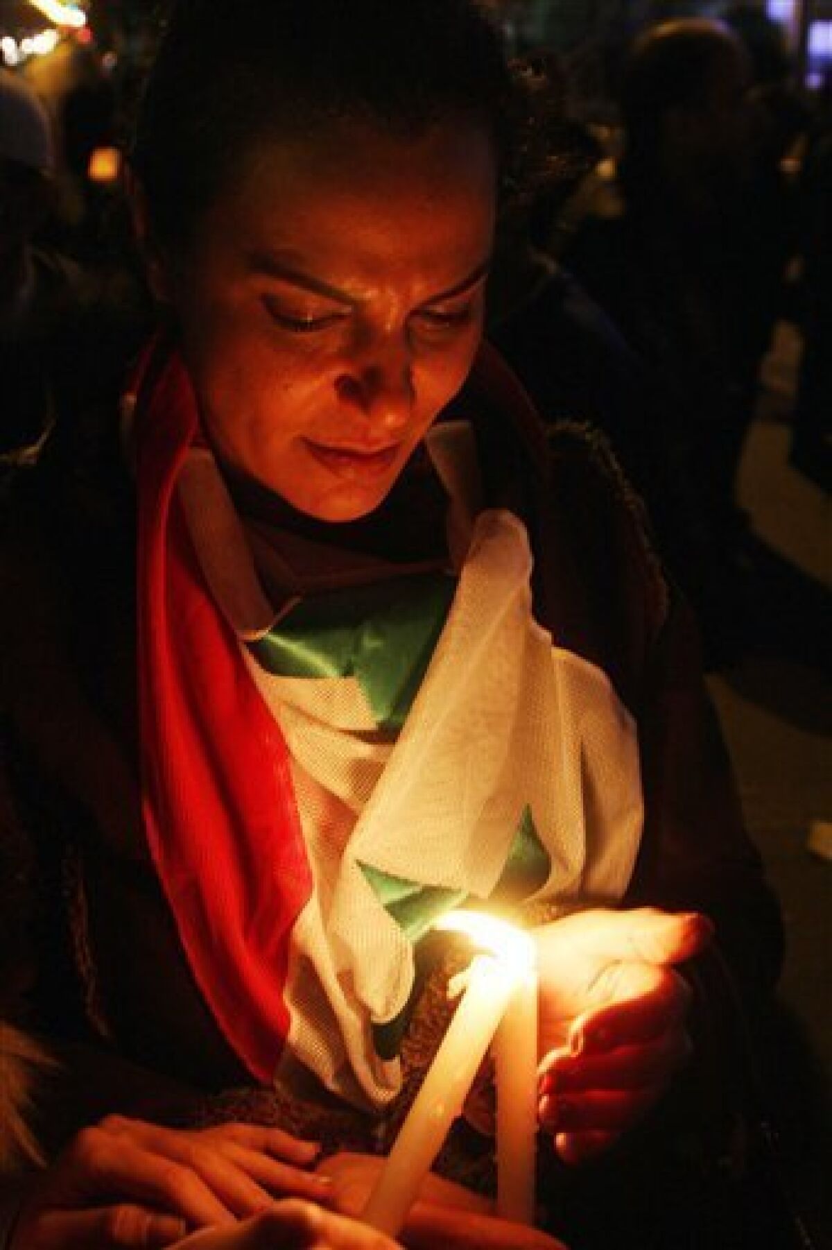 A Syrian woman lights a candle from other demonstrators during a vigil held at Sabe Bahrat Square in Damascus, Syria on Saturday, Dec. 10, 2011 in a show of solidarity with Syrian President Bashar Assad and in memory of Syrians who were killed during the unrest in the country. (AP Photo/ Bassem Tellawi)