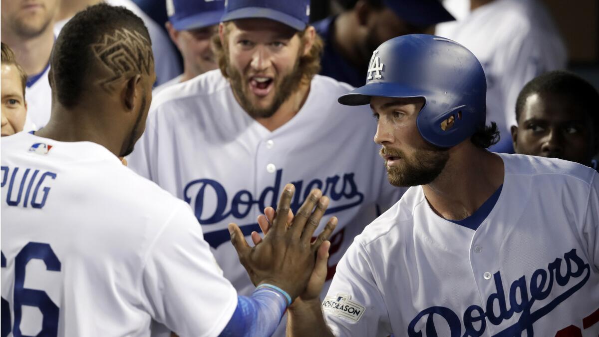 Shortstop Charlie Culberson is congratulated by Yasiel Puig after scoring to tie the game up.