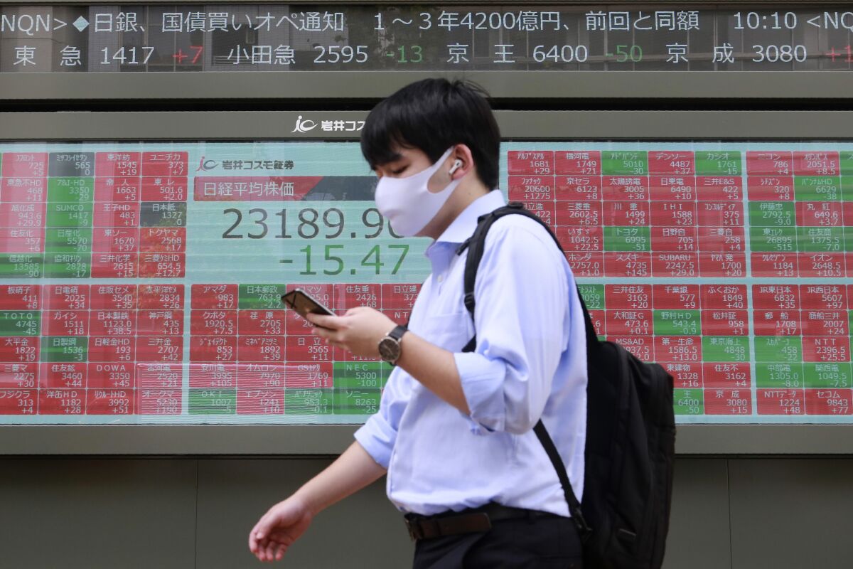 A man walks by an electronic stock board of a securities firm in Tokyo, Monday, Sept. 7, 2020. Asian stock markets were mixed Monday after Wall Street turned in its biggest weekly decline in more than two months.(AP Photo/Koji Sasahara)