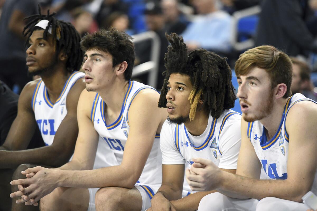 UCLA's Jalen Hill, Jaime Jaquez Jr., Tyger Campbell and Jake Kyman (left to right) look on from the bench during a game against Colorado on Jan. 30 at Pauley Pavilion.