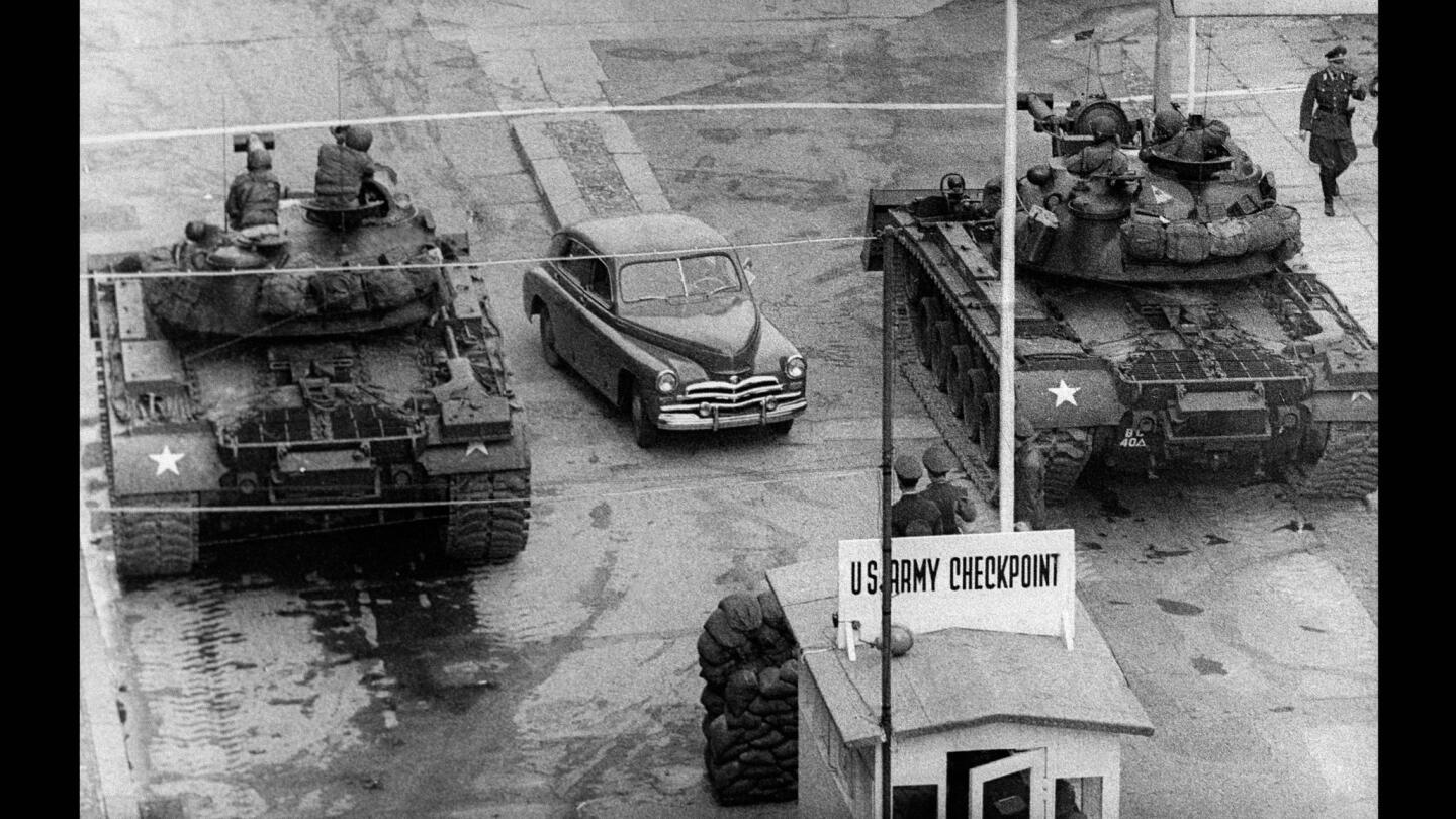 A car drives between U.S. tanks in October 1961 toward the famous Checkpoint Charlie border crossing between West and East Berlin.