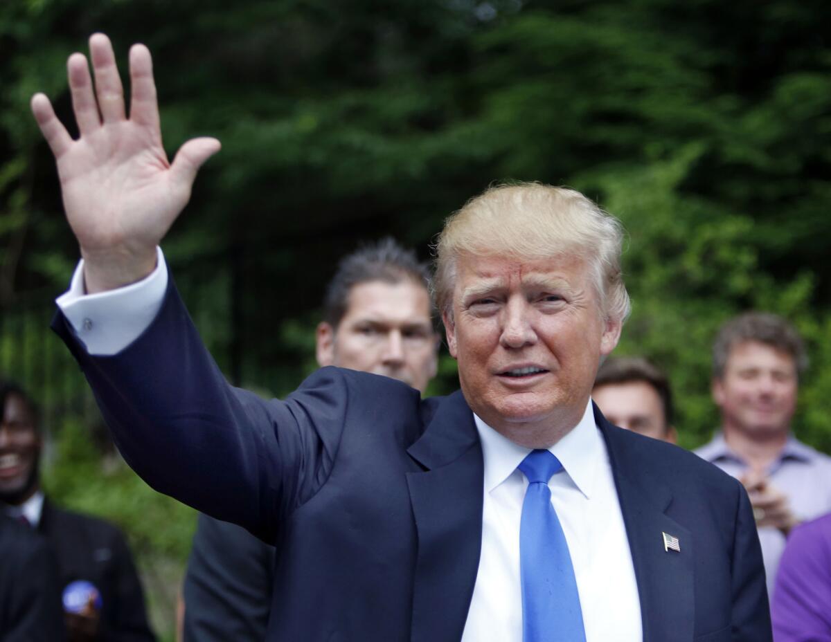 En esta foto del 30 de junio de 2015, el precandidato republicano Donald Trump saluda al llegar a una casa en Bedford, New Hampshire, para una fiesta.