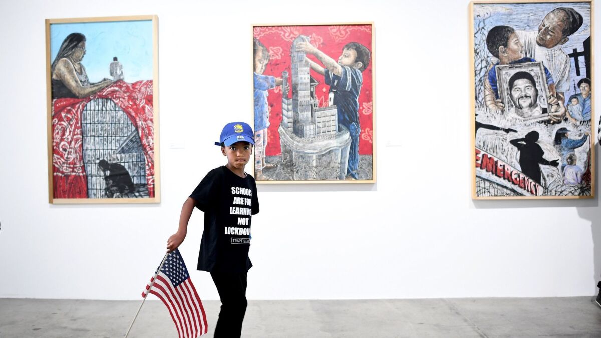 Elijah Goodspeed, 6, carries a flag while touring the art gallery Monday at the Los Angeles Department of Mental Health, which is sponsoring the "We Rise" event in downtown L.A. The gallery will remain open to the public through June 10.