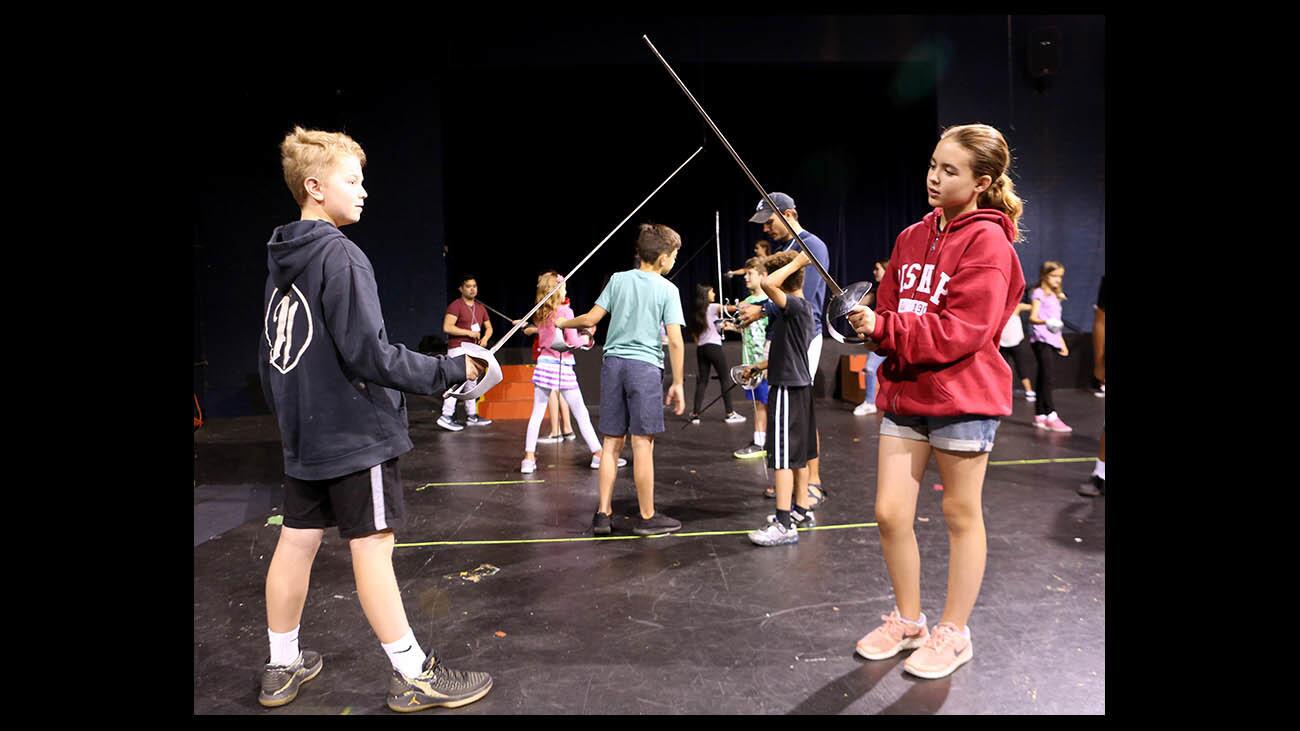 Alex Swift, 12, left, and Eva Blakely, 11, right, practice sword fighting at the Providence High School 8th annual Summer Acting Camp, in Burbank on Tuesday, July 3, 2018. The campers split up into different groups that participate in other activities like movie making and dancing as well.