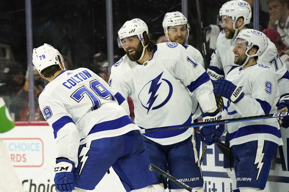Tampa Bay Lightning left wing Pat Maroon (14) congratulates center Ross Colton (79) following Colton's goal against the Carolina Hurricanes during the third period in Game 5 of an NHL hockey Stanley Cup second-round playoff series in Raleigh, N.C., Tuesday, June 8, 2021. (AP Photo/Gerry Broome)
