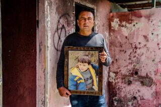 Abed Salama holds up a photo of his son, Milad, who was killed in a school bus accident near Jerusalem.