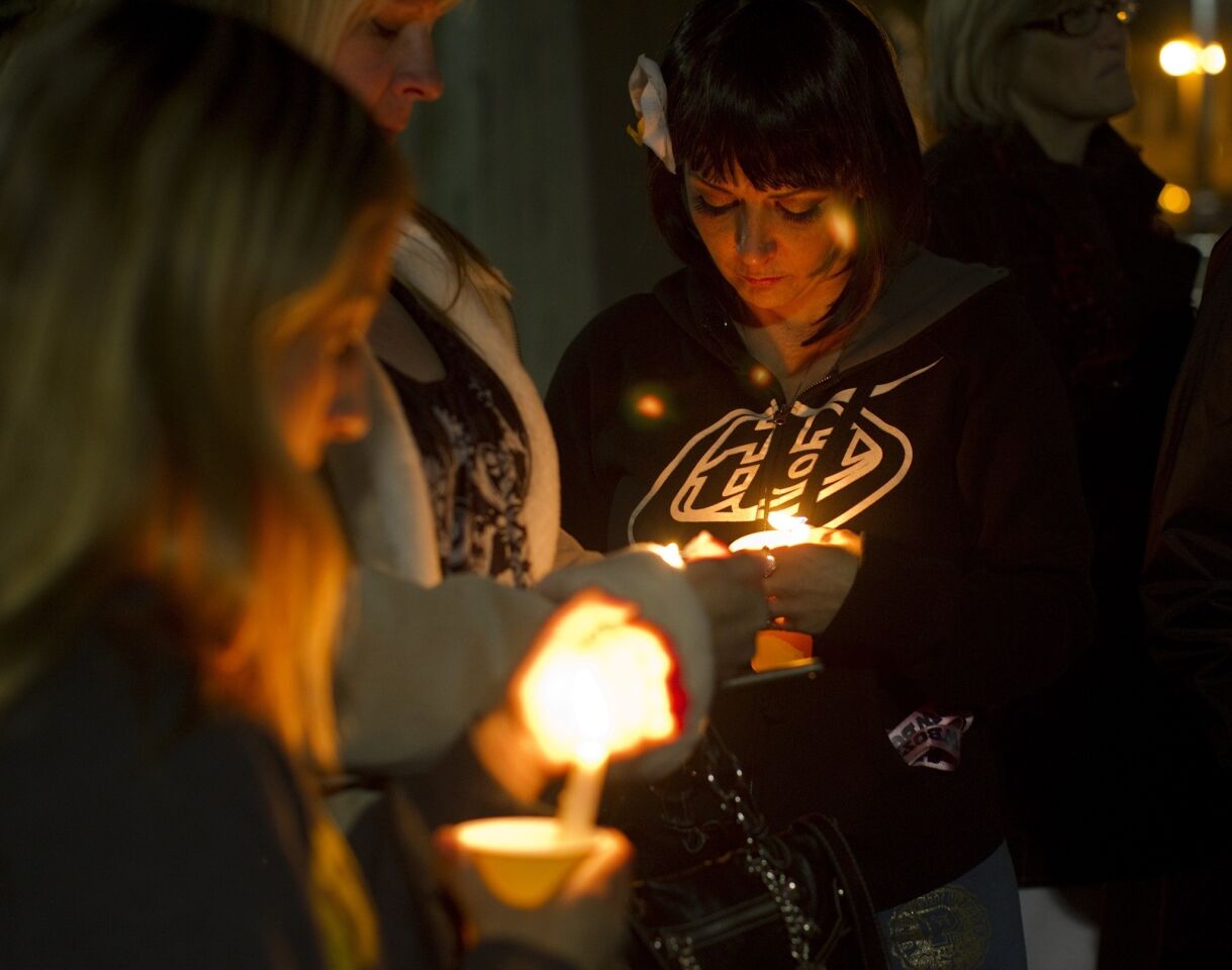 Riverside residents hold candles during a vigil at City Hall for the slain and wounded Riverside police officers.