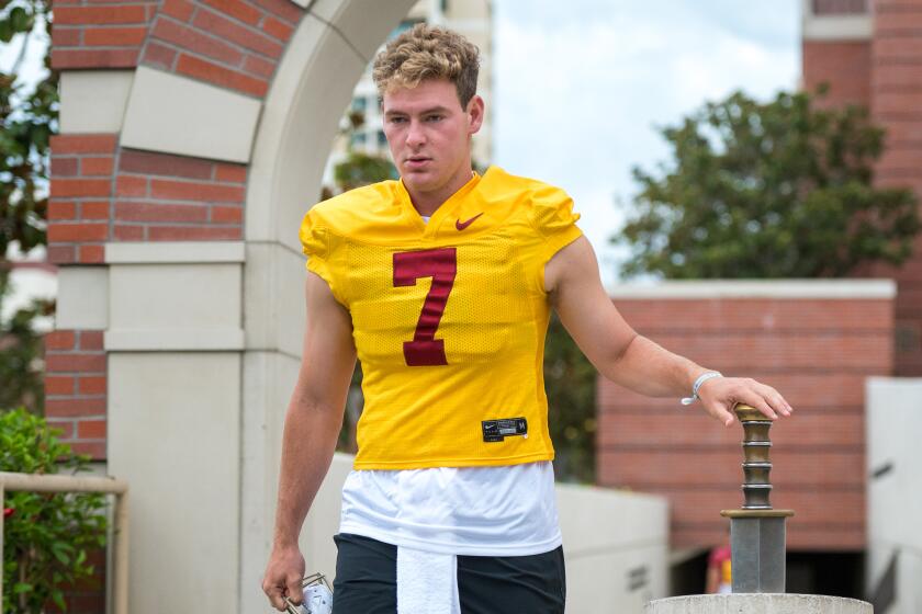 LOS ANGELES, CA - AUG. 5, 2022: USC quarterback Miller Moss taps a sword.