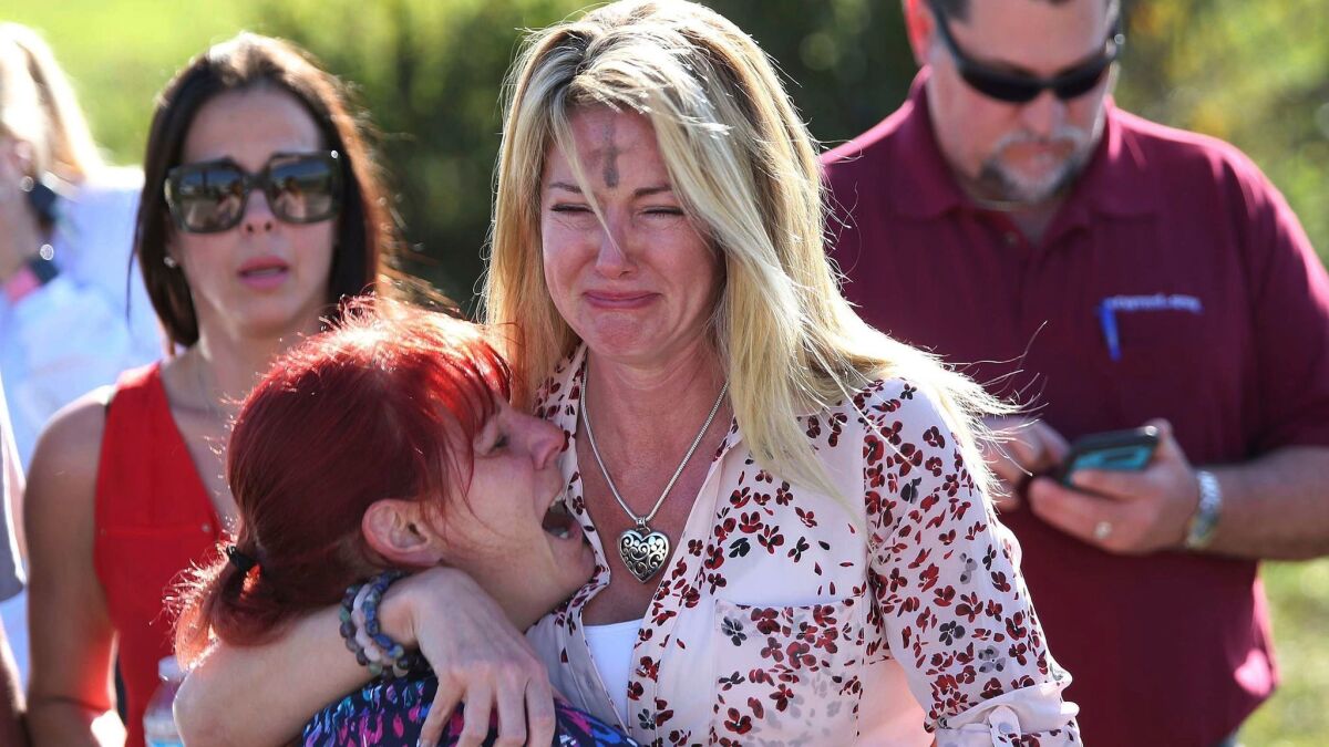 Parents wait for news after a reports of a shooting at Marjory Stoneman Douglas High School in Parkland, Fla., on Feb. 14.