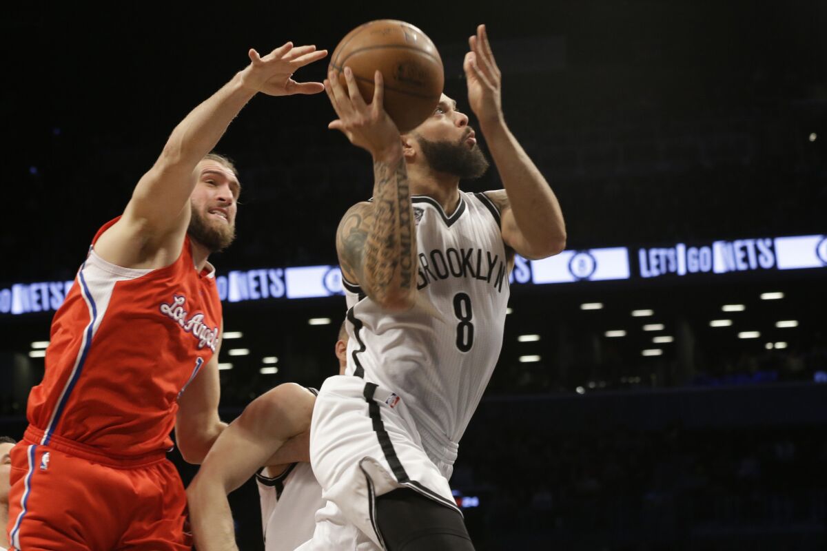 Clippers center Spencer Hawes tries to block the shot of Nets point guard Deron Williams.